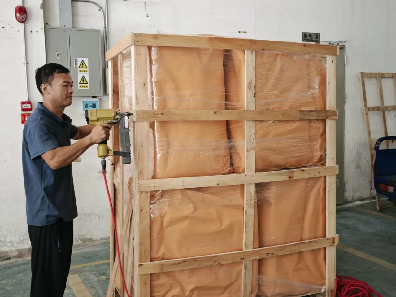 Packing specialist fastening a timber export frame around protected cargo